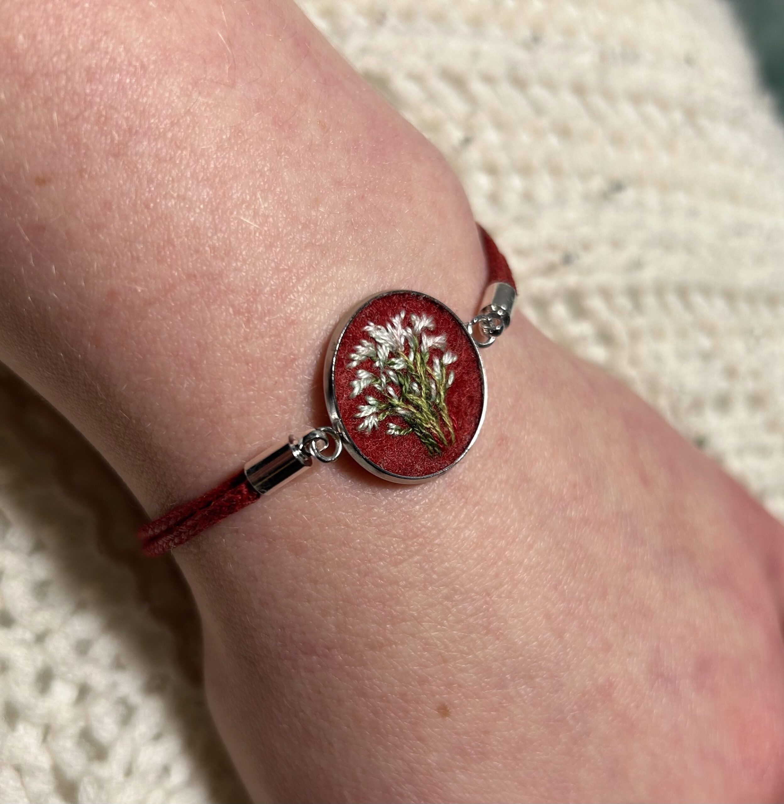 Bransoletka z białymi kwiatami na bordowym tle haftowana robiona ręcznie